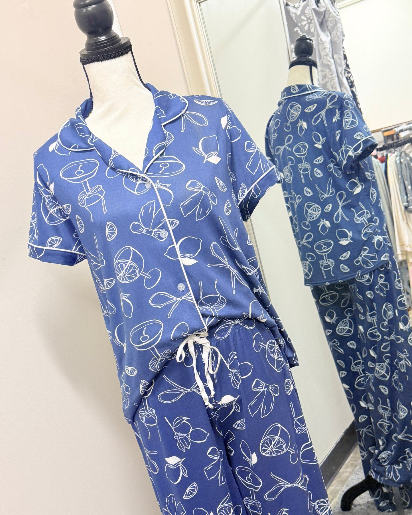 Blue pajama set with white patterns on a mannequin against a neutral background