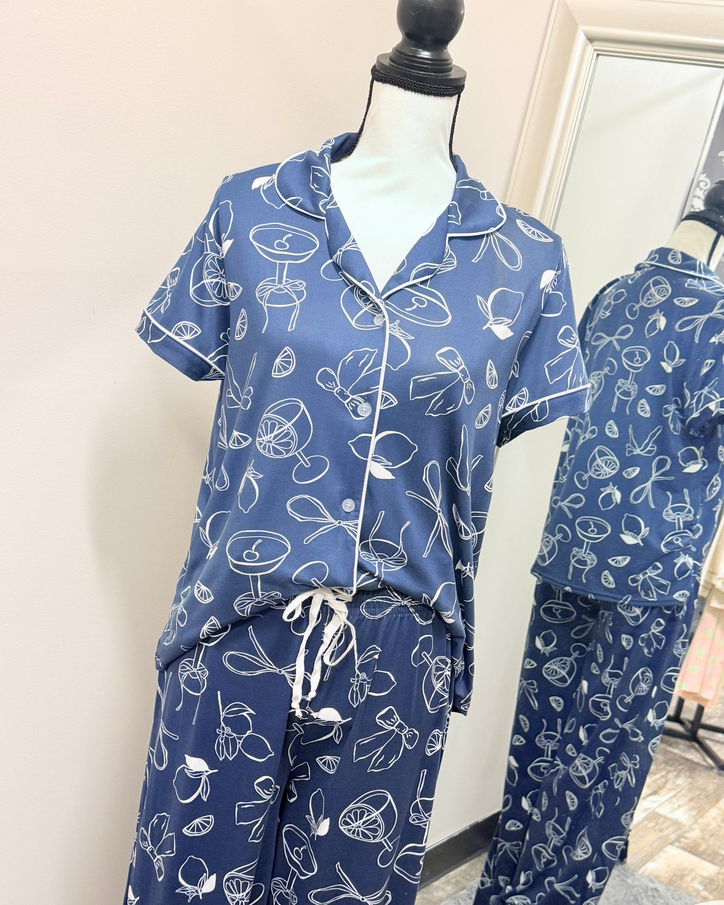 Blue pajama set with white patterns on a mannequin against a neutral background