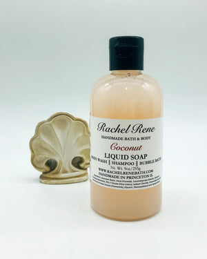 A cloudy cream-colored liquid soap with a white label that reads "Rachel Rene: Handmade Bath & Body - Coconut. Liquid Soap - Body Wash - Shampoo - Bubble Bath." It has a black pull top cap and sits on a white background.