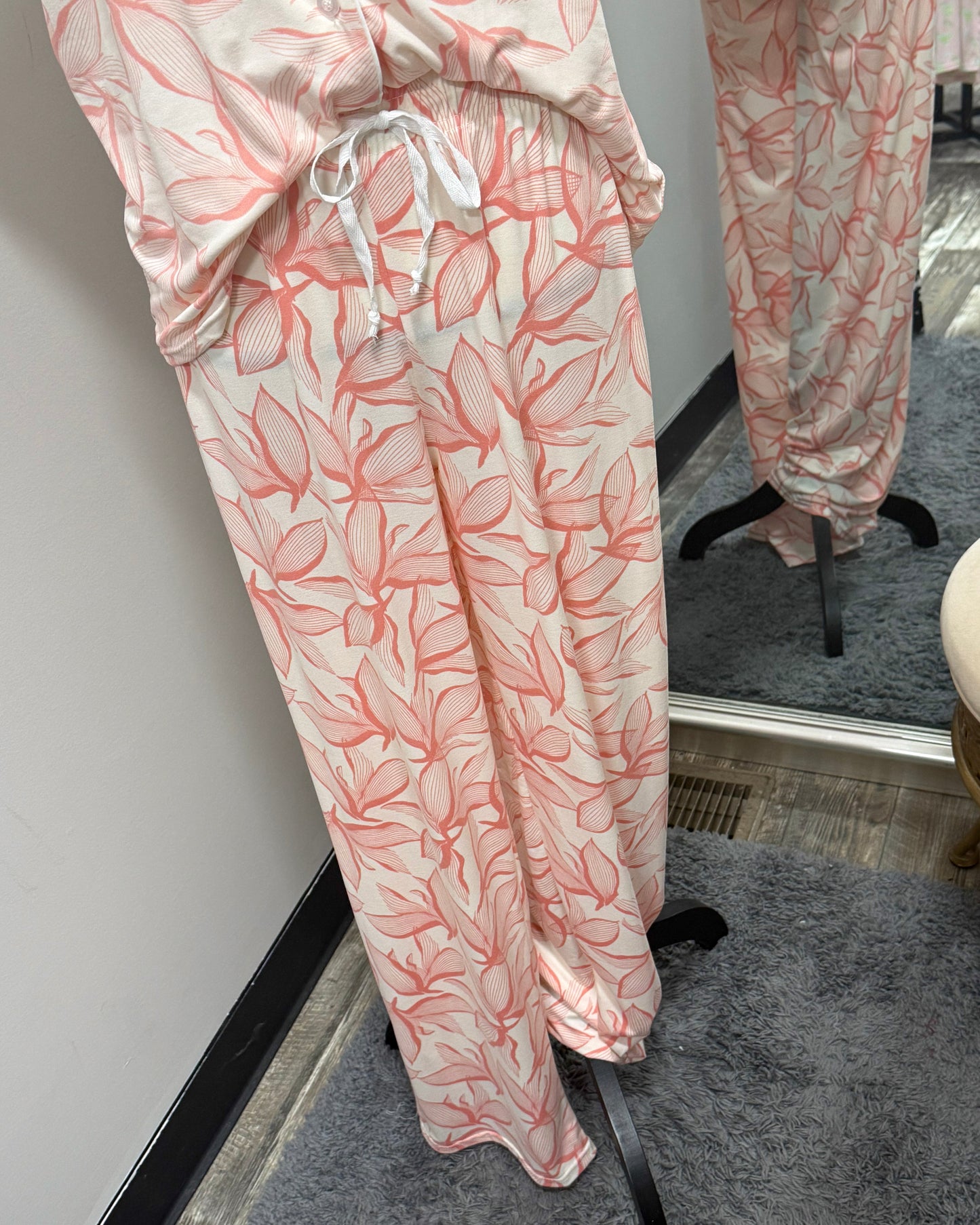 Pink floral pajama set on a mannequin with a mirror reflection.