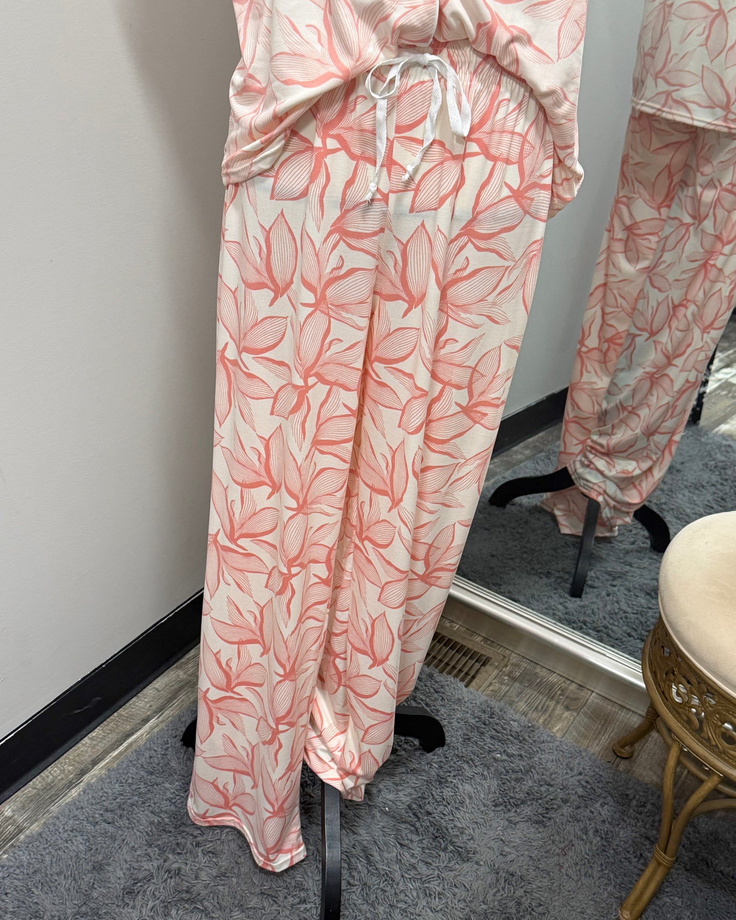 Floral pajama set on a mannequin against a white wall.