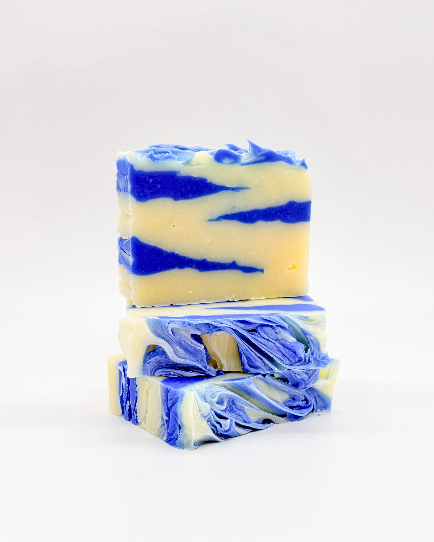 Three bars of blue and white tiger striped soap stacked on a white background