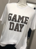 A white short sleeve tee with bold text in leopard print reading "GAME DAY".