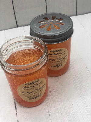 
            
                Load image into Gallery viewer, Orange jelly crystals in a clear glass jar. The lid has holes in a flower design. A tan label reads &amp;quot;Mango Papaya&amp;quot;
            
        